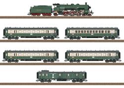 TRIX HO - art. 21360 - KPEV Set Bavarian Express Epoca I - SOUND, TRIX HO - art. 21360 - KPEV Set Bavarian Express Epoca I - SOUND
L'aumento del carico dei treni all'inizio del XX secolo richiedeva unità più potenti anche in Baviera. Nella prima parte del 1907 Maffei ottenne quindi l'appalto per la costruzione di una locomotiva composita Pacific per la Ferrovia Bavarese. Già nel luglio del 1908 la prima unità lasciò la casa costruttrice. Nello stesso anno la seguirono altre sei locomotive (numeri di servizio 3601-3607). Nel 1911 Maffei consegnò altri 16 esemplari per lo più identici in tre serie di costruttori (da a a c) (numeri di servizio 3608-3623). A partire da queste prime 23 locomotive, le successive 18 unità (Serie d ed e, Maffei 1912/1913, numeri di servizio 3624-3641) furono dotate di ruote motrici con diametro 2.000 mm / 78-3/4" anziché 1.870 mm / 73 -5/8". Ciò ha anche fatto sì che la caldaia si trovasse più in alto su queste unità e sono state rapidamente conosciute come "High Steppers". Le locomotive avevano inizialmente sede a Monaco presso la stazione centrale e da lì circolavano principalmente su treni espressi in tutte le direzioni, come la linea Monaco - Ulm - Stoccarda.
Set composto da una locomotiva a vapore per treni rapidi Gruppo S 3/6 "High Stepper", tre carrozze per treni rapidi CCü di 3ª classe, una carrozza per treni rapidi ABBü di 1ª/2ª classe e un treno rapido PPü Bagaglio. Percorso ferroviario Stoccarda - Ulma - Augusta - Monaco di Baviera. Reale Ferrovia dello Stato Bavarese (K.Bay.Sts.B.). Numero di servizio della locomotiva 3629. Condizioni di esercizio intorno al 1912. Carrozze passeggeri in colorazione verde bottiglia/avorio.

La locomotiva a vapore è costruita principalmente in metallo. Il carrello è finemente costruito in metallo pressofuso con un telaio a barre parzialmente aperto. C'è una visuale aperta attraverso la marcia. La cabina è modellata in dettaglio. Le lampade sono progettate per essere bianche. La locomotiva è dotata di motore ad alta efficienza a 5 poli con volano. La locomotiva dispone inoltre di un'unità fumogena montata in fabbrica, una cabina di guida illuminata, una luce per i treni in arrivo, che può essere controllata in modalità digitale, un decoder mfx e numerose funzioni sonore. È presente un meccanismo di aggancio corto tra locomotiva e tender con "posizione vetrina". Il tender ha intricati gradini delle porte della camera del fumo e sono inclusi un accoppiatore a gancio e un tubo dell'aria sul retro, nonché manicotti protettivi per l'asta del pistone. Le autovetture sono modellate in dettaglio e sono a grandezza naturale. Hanno anche ruote a raggi. Lunghezza totale ai respingenti circa 135 cm / 53-1/8".
